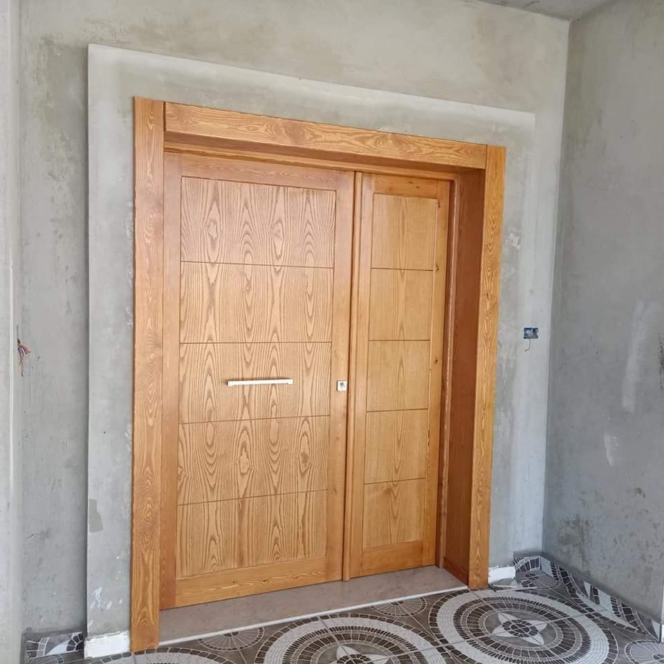 Porte bois à panneaux rectangulaires dans un encadrement maçonné