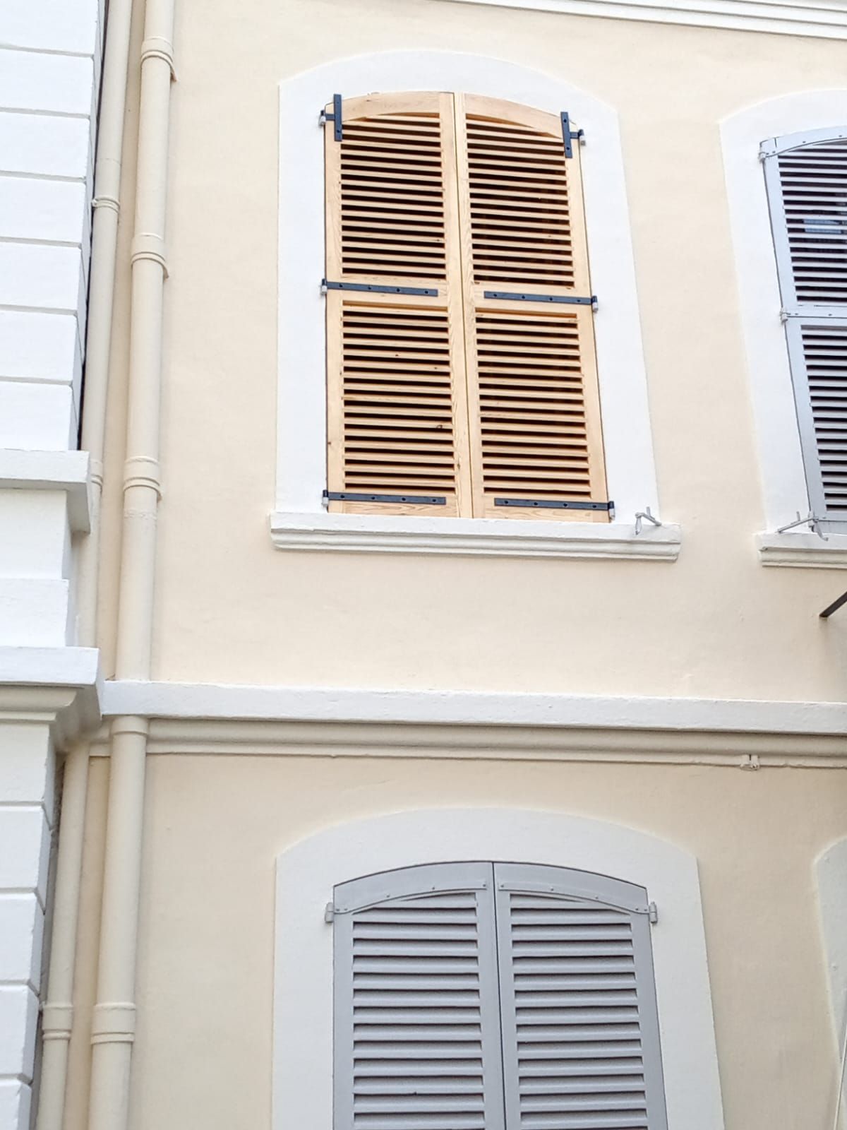 Volets à persiennes sur une façade claire