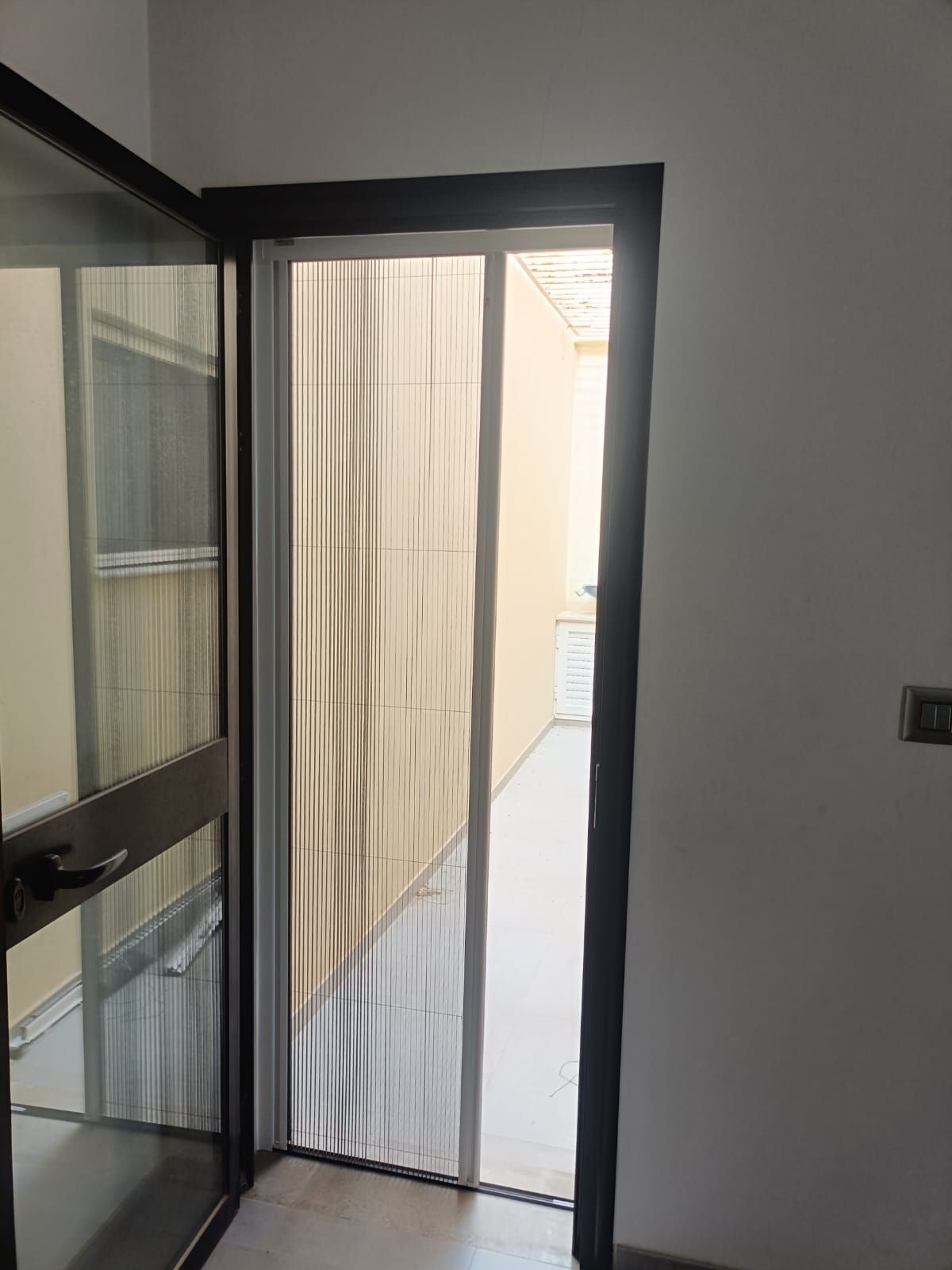 Moustiquaire sur une porte vitrée